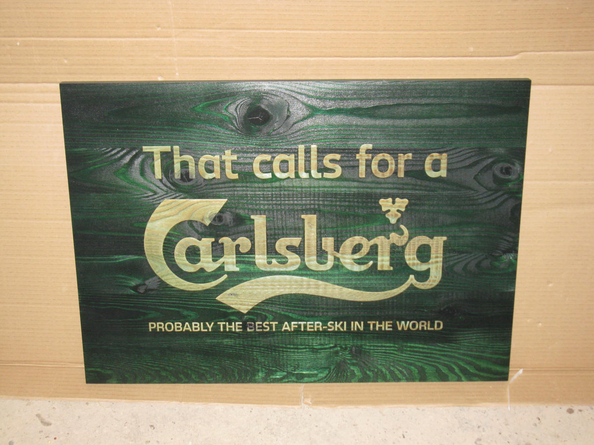 PIKUSA-näyttö logolla, puu seinällä